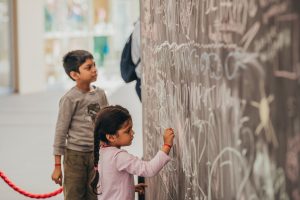 Chalk board area for kids, free drawing with chalk, little girl drawing on board, interactive drawing boards