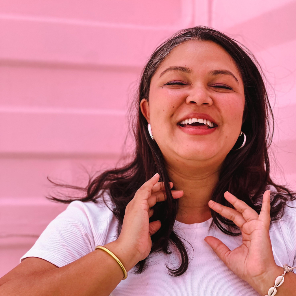 Mauritian girl smiling, Marie-Christine, pink background, closed eyes